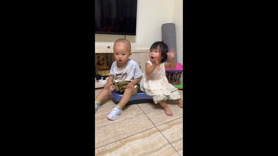 Two children enjoy a shaking vibration platform in Guizhou, China