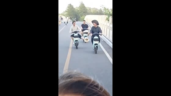Cyclist loses hat as another rider catches it with his foot in Anhui, China