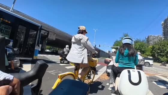 Cyclist falls into an e-bike while trying to overtake at an intersection in Beijing, China