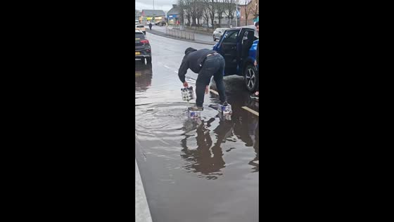 Man balances on Red Bull cans to cross flooded road in Glasgow, Scotland