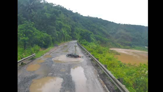Motorbike rider falls into puddle on pothole-ridden road in Quảng Trị, Vietnam