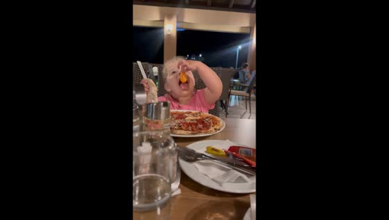 Little girl enjoys rich egg yolk on pizza in Kaonik, Bosnia and Herzegovina