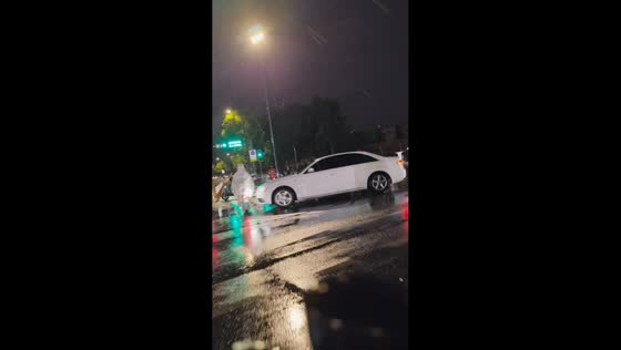 Car strikes motorcyclist at rainy intersection in Sichuan, China