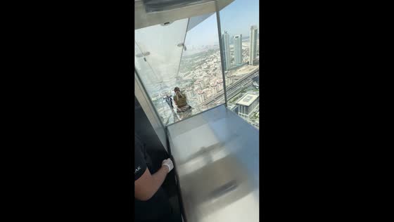 Woman's slow glass slide moment in Sky View, Dubai, UAE