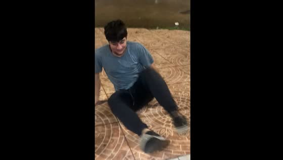 Person slips and falls after placing paper boat in rain water in Chivilcoy, Argentina