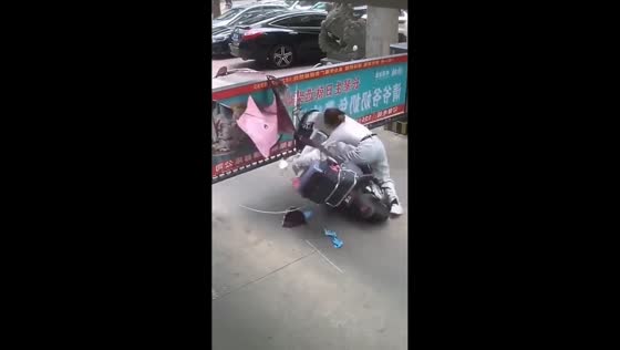 Motorcycle rider caught on the edge of a gate in Guangzhou, China