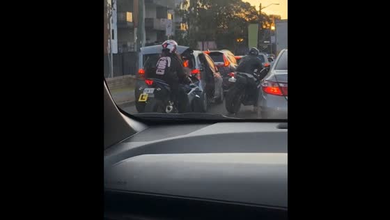 Motorbike rider opens car door in traffic after car passenger disables bike as a joke