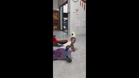 Upset little boy trips and falls over toy cart in Guangdong, China