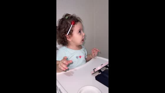 Little girl struggles to remove lollipop stuck in her hair in Baku, Azerbaijan