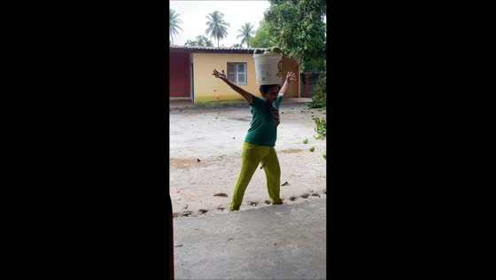 Woman balancing a pail of fruit falls in Pindoretama Ceará, Brazil