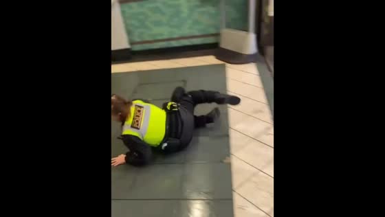 Police officer stumbles on wet ground during station rush in London, UK