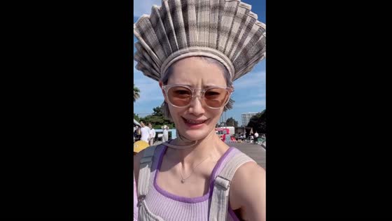 Wind turns hat brim up, creating stylish moment