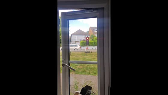 Traffic light points red toward house in Hemel Hempstead, England, UK