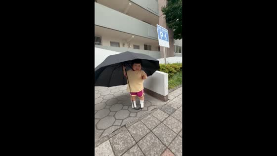 Toddler charms with oversized umbrella stroll in Daejeon, South Korea