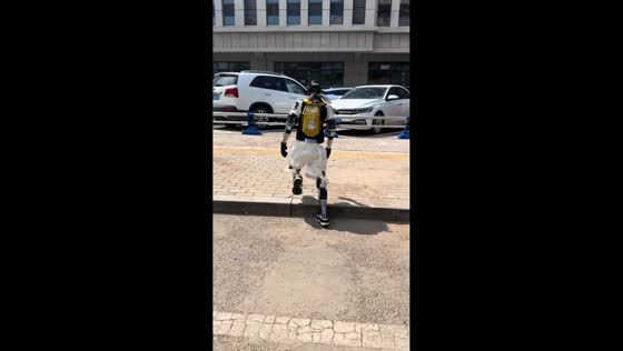 Robot wearing backpack trips on street gutter in Inner Mongolia, China