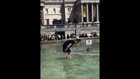 Woman collects coins from the Fountain in Trafalgar Square, London, England, UK