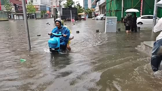 Scooter rider navigates deep floodwaters in Zhejiang, China