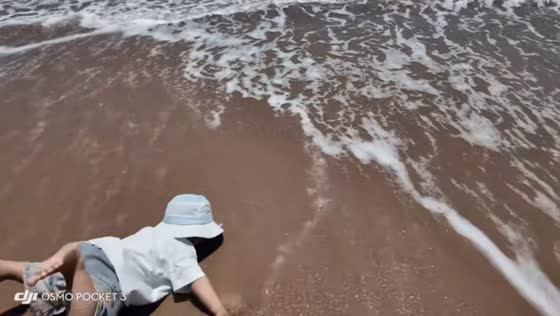 Toddler tumbles on beach after tiny wave came in Shandong, China