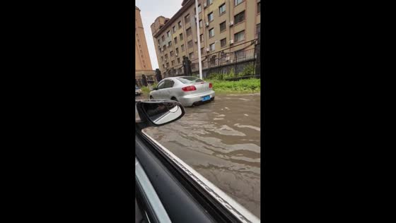 Woman slips while walking through flooded sidewalk in Heilongjiang, China