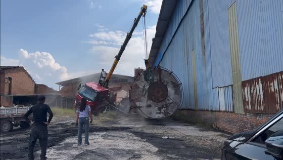 Crane truck overturns while lifting large storage tank near warehouse in Henan, China