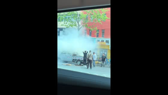 People help extinguish fire on parked truck in Liaoning, China