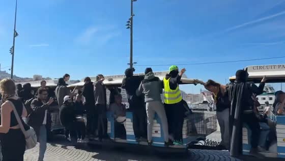 Protesters gather around a tourist road train during a street demonstration in Marseille, France