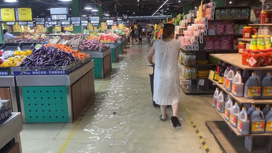 Floodwater fills supermarket aisles as shoppers wade through water in Zhejiang, China