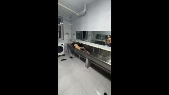 Men playfully swim in laundry trough in Liaoning Province, China