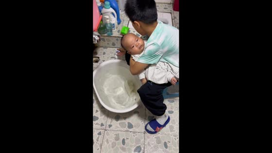 Older brother gently washes baby sibling in Jiangxi, China