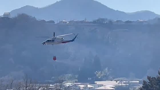 Helicopter collects water to fight forest fire in Yamanashi, Japan