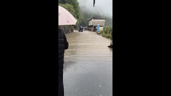 Heavy flooding leaves vehicles stranded on a mountain road in Shaanxi, China