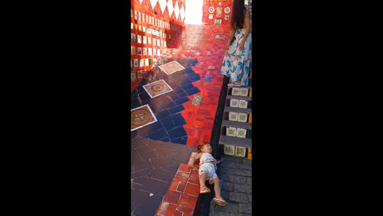 Little girl slips into gutter during playful stair slide in Rio de Janeiro, Brazil