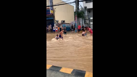 Children play in floodwaters caused by typhoon Gaemi in Cainta, Rizal, Philippines