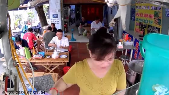 Cat sits overhead watching its owner prepare food at Ho Chi Minh City eatery
