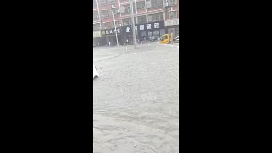 Flooded road as vehicles continue driving through high water in Guangdong, China