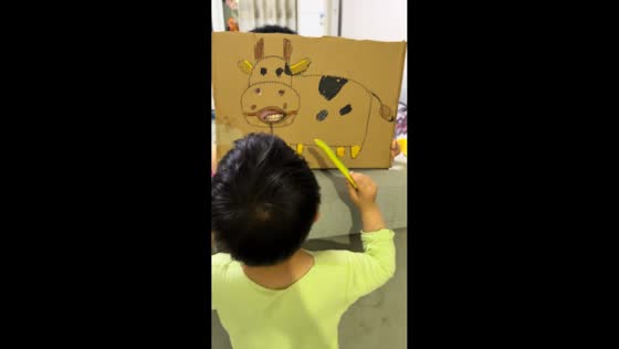 Boy playfully feeds father through cardboard cow in Shanxi, China