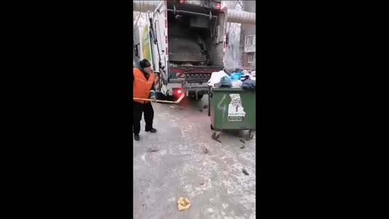 Utility worker chases rats with hockey club near garbage container in Omsk, Russia