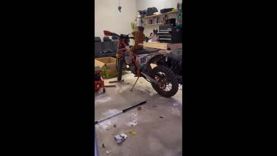 Little boy starts dirt bike in garage in Milford, Massachusetts, USA