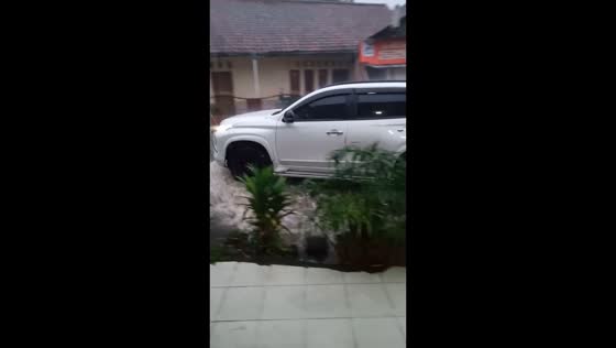 Car loses bumper while driving through flooded road in Bogor, Indonesia