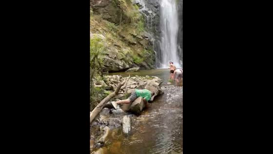 Person slips and falls on rocks near waterfall in Galicia, Spain