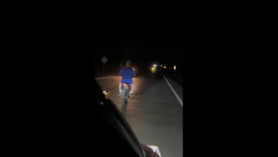 Motorcycle rides with damaged wheel on highway in Copán, Honduras