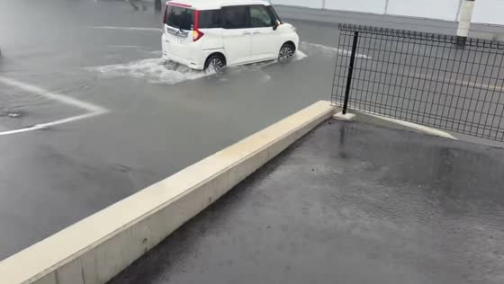 Floodwaters inundate roads and parking areas during heavy rain in Ichihara, Japan