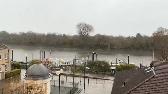 Snowfall sweeps across the Thames River in Chiswick, London