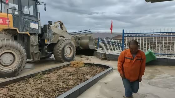 Wheel loader breaks concrete barrier to drain floodwater in Xinjiang, China