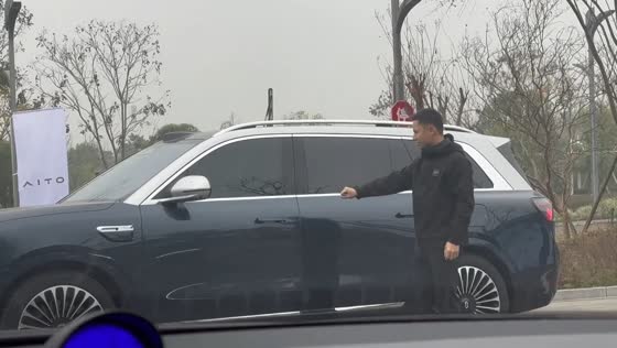 Man humorously “controls” car with hand gestures beside AITO M9 in Sichuan, China