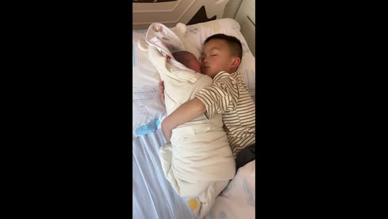 Young boy gently comforts newborn sibling in Guizhou, China