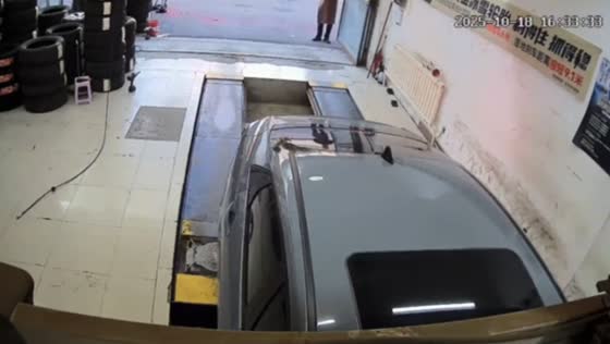 Car nearly falls into repair pit inside workshop in Jilin, China
