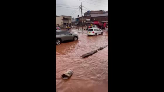 Truck tips in deep floodwater as vehicles pass through in Bwaise, Kampala, Uganda