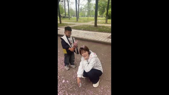 Boy playfully pours flower petals on woman in Shaanxi, China