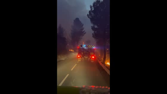 Firefighter vehicle passes through intense wildfire flames in Durban-Corbières